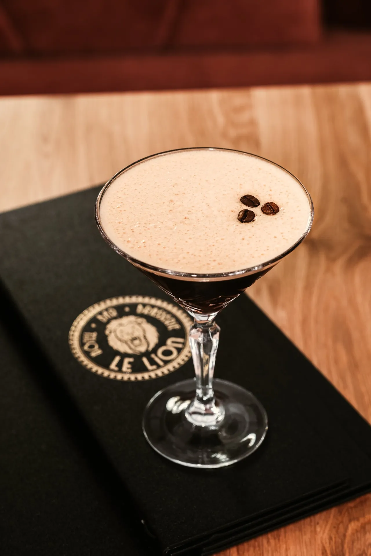 Espresso martini posé sur un porte-menu gravé au lion de l’Hôtel Le Lion